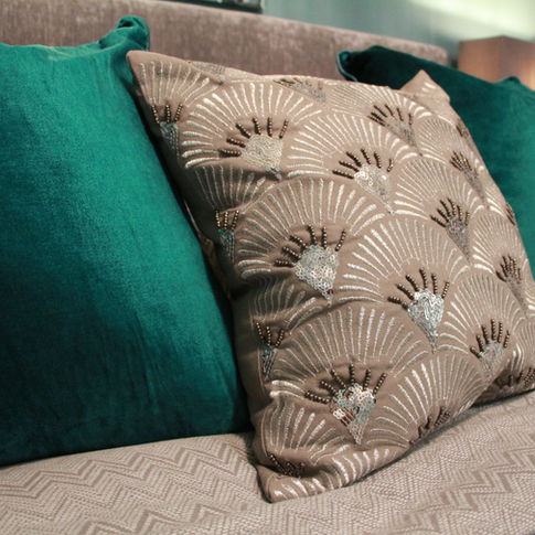 Two velvet green cushions and an art deco style scalloped cushion.