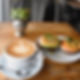 Latte and bagel sandwich on table top