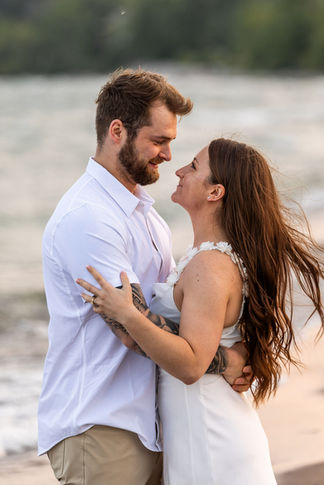 Golden hour engagement photography at Frenchman’s Bay featuring natural candid moments by the lake