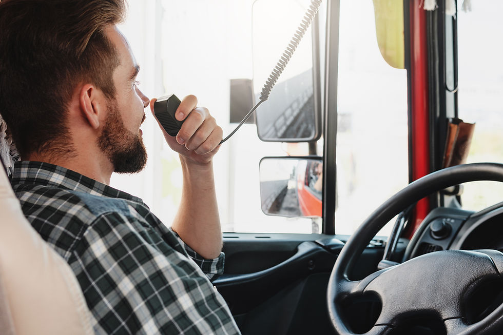 Commercial truck driver speaking into a CB radio inside the cab