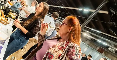 Eine Kundin macht eine Riechprobe - Weißwein. – aufgenommen bei der Weinmesse „Wein trifft Genuss“ in Steyr.