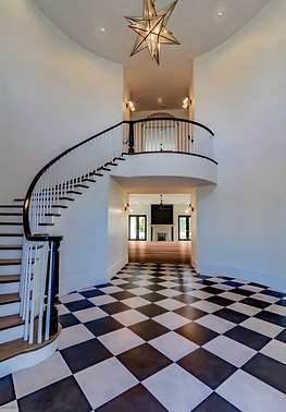Custom staircase in grand entry with black and white checkered flooring