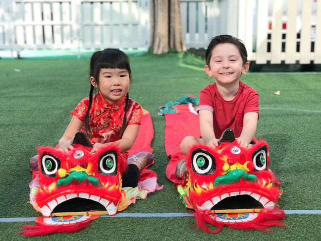 Children playing with lion dance heads