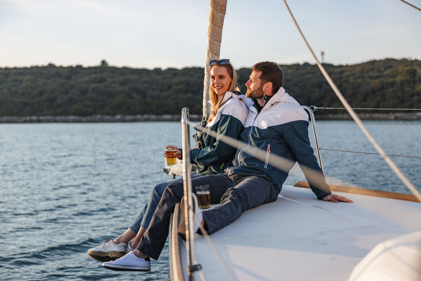 Couple sailing ant enjoying a beer