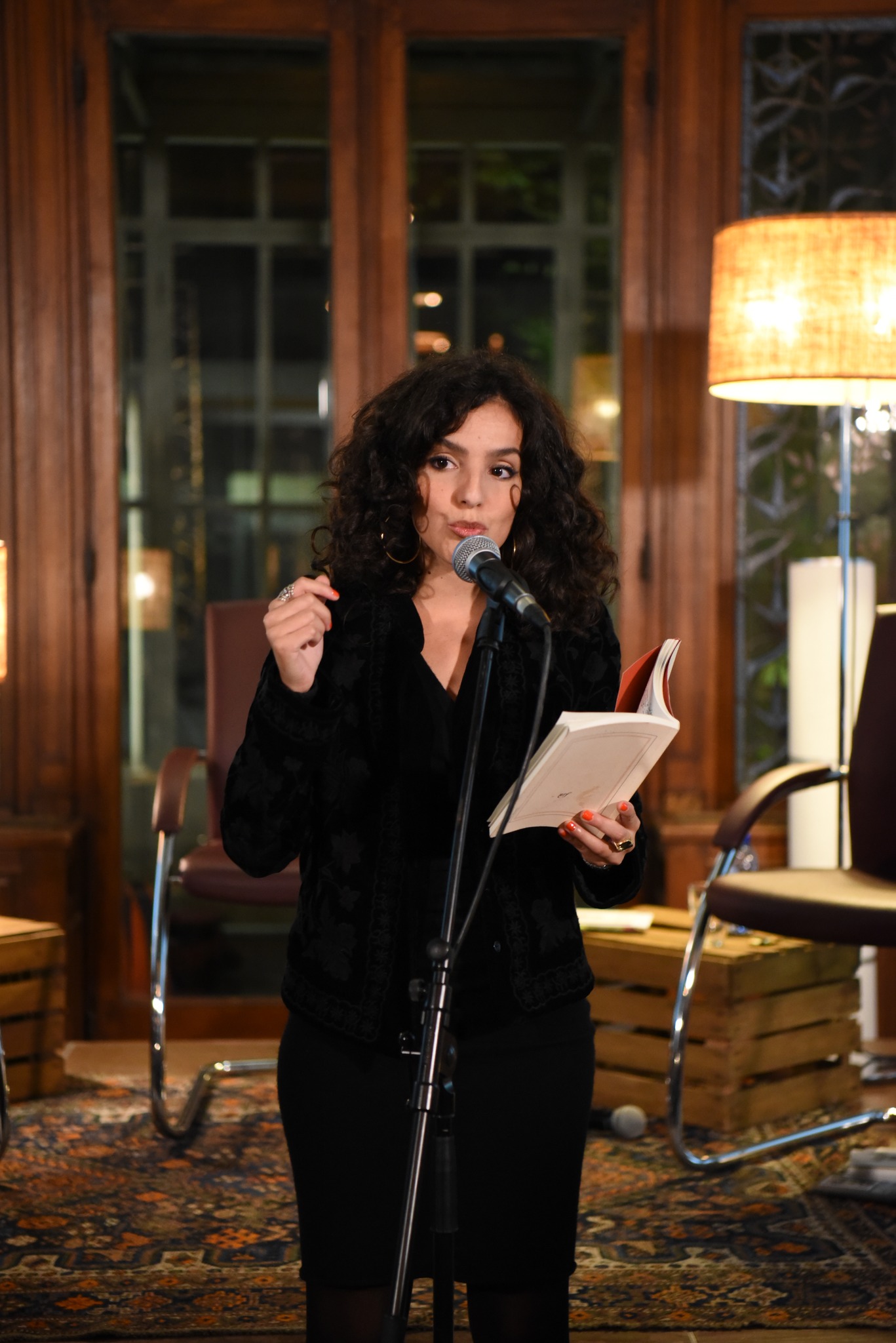 Anaïs Souada lisant un texte au micro lors d’une soirée de poésie