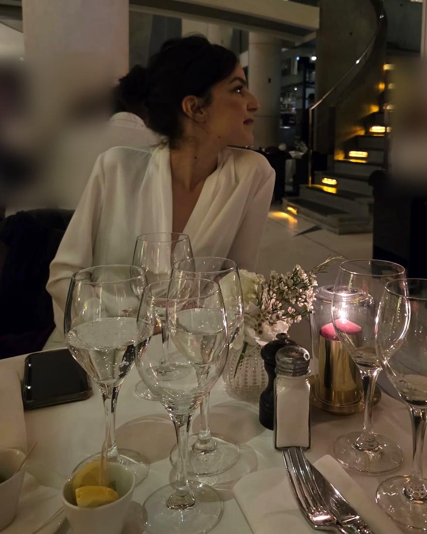 Anaïs Souada attablée dans un restaurant, de profil, devant une table dressée