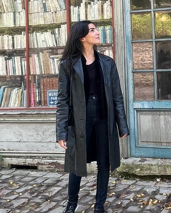 Anaïs Souada devant une librairie ancienne, le regard levé