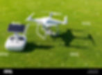 white-professional-quadcopter-drone-camera-with-remote-control-from-above-against-green-gr