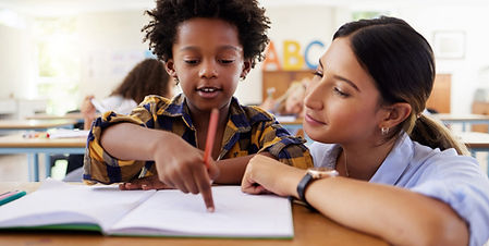 teacher helping young boy in class
