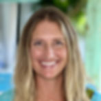 A lady smiling with a garden-like background.