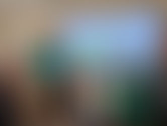 A group of people in a room smiling with a sign in the background.