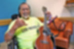 A man on a mobile chair holding a ukulele.