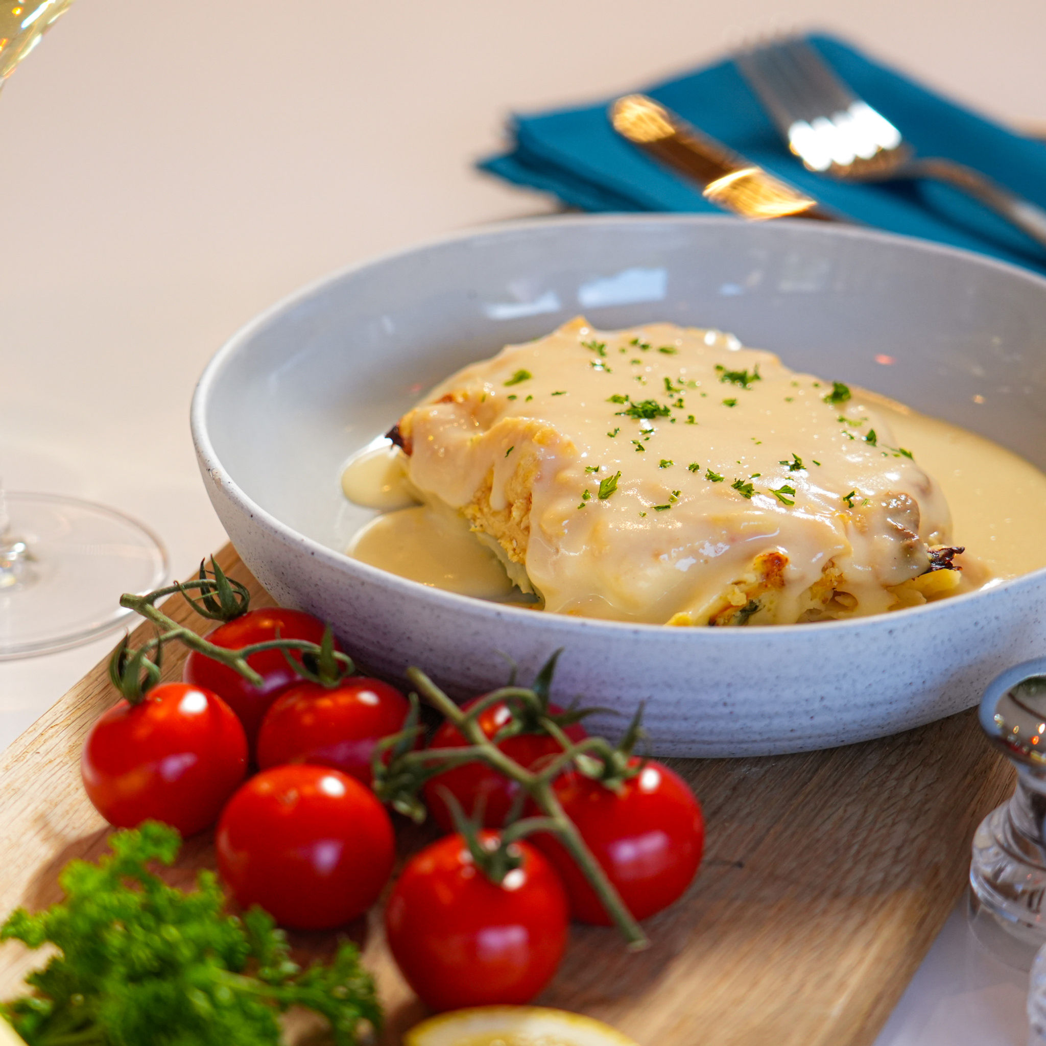 Sourced Meals Cod Mornay in a grey bowl with vine tomatoes and fresh herbs