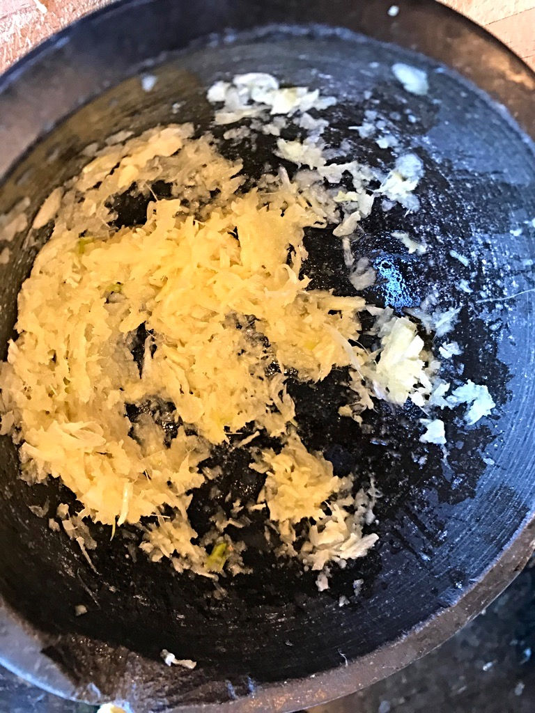 Crushing garlic and ginger for Sri Lankan Chicken Curry
