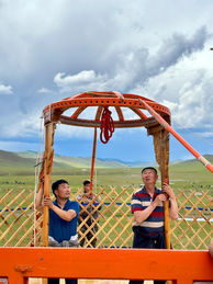 People building a Ger with panoramic views of the Mongolian landscape.