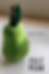 Green felt pear with brown stem and green leaf on a white surface. Text reads "HOW TO MAKE" and "FELT PEAR" in black.