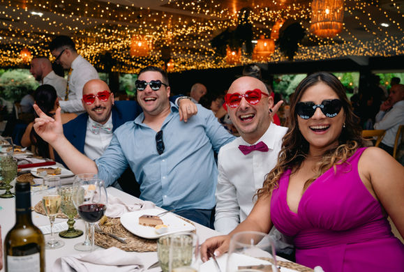 Invitados en Galeria V&O celebrando con gafas divertidas.