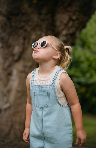 Niña con gafas de sol en sesión de fotos familia y bebé.