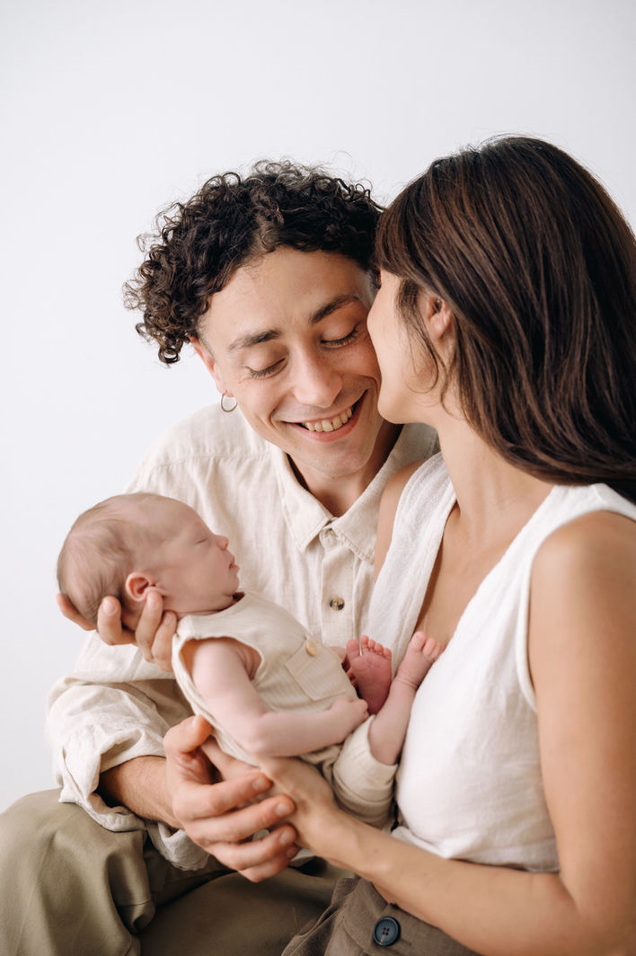 Pareja sonriente con su bebé recién nacido en Avilés.
