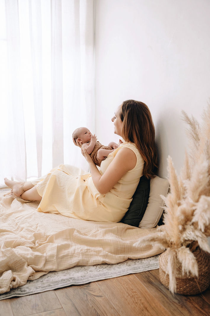 Madre sosteniendo a su bebé recién nacido en brazos.