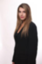 אישה עם שיער בלונדיני ארוך לובשת מעיל שחור