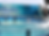 Foto da orca Lolita saltando da água, em seu espetáculo no Miami Seaquarium, com treinadoras ao fundo da imagem.