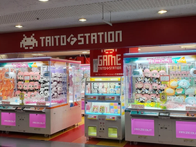 Neon-lit retro arcade in Motomachi, Kobe, near Sannomiya Station—filled with claw machines, classic games like Street Fighter, and a mix of locals and visitors enjoying nostalgic gaming culture and nightlife after shopping or dining near Tor Road and Chinatown.