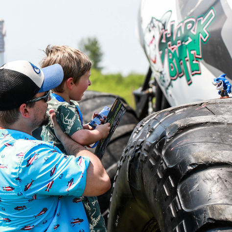 Dad and son looking close up at a monster truck