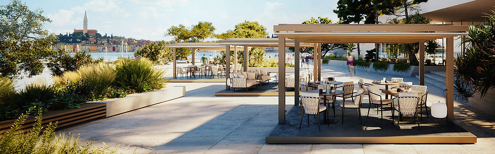 Outdoor cafe with tables and chairs under phoenix pergolas, lush greenery, and a view of a colorful town across the water on a sunny day.