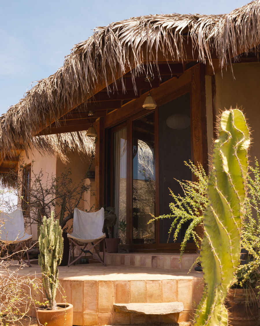 Located in the desert of Baja, the Arte y Mano Taller is a unique tiny house designed and built by Diego Blanes, a skilled carpenter and alternative builder, with artistic contributions from Renata, an accomplished artist. This off-grid home combines functionality with aesthetic charm through the seamless integration of natural materials.
The structure encompasses an area of 18 m² (194 ft²), with an additional 12 m² (129 ft²) dedicated to a separate bathroom. The main building features a cozy loft bedroom situated above the living room. The kitchen is crafted from parota wood and adorned with artisanal Mexican tiles, while the flooring is made of lime, ensuring a sustainable approach. The house is constructed primarily from adobe, complemented by a traditional three-coat lime plaster on the exterior and a special Oaxacan clay finish on the interior.
All materials were selected to minimize environmental impact, with no cement used in the construction apart from the stone foundation sourced from local rocks.
Project credits
Architects: Diego Blanes
Photography: Marcella Bijou
Location: Todos Santos, BCS, Mexico