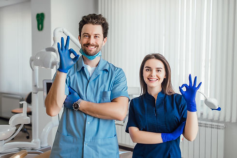 photo-smiling-dentist-standing-with-arms-crossed-with-her-colleague-showing-okay-sign (1).