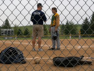coach and youth ump standing talking on baseball field