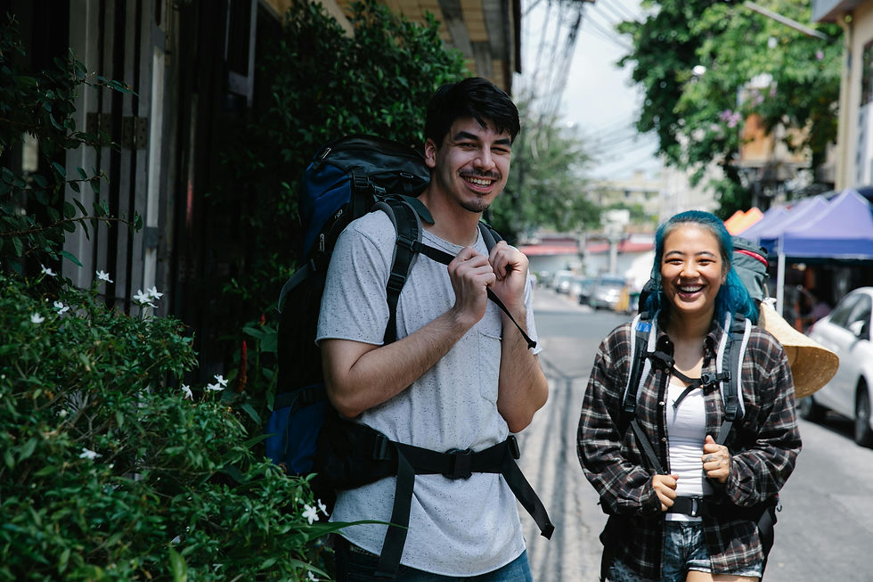 Man and woman smiling carrying their backpacks.