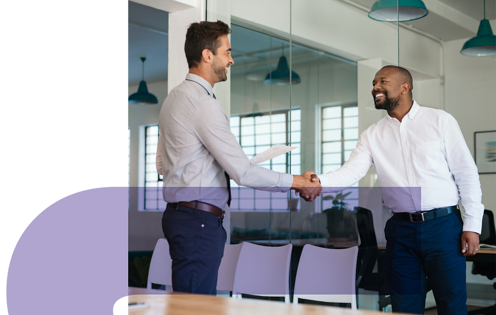 Two professionals shaking hands in an office setting.
