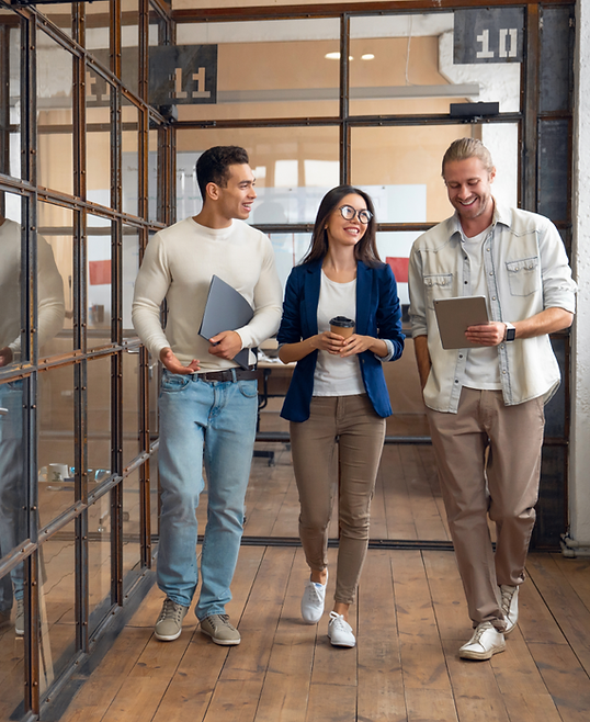 Colleagues walking and talking in a modern office hallway