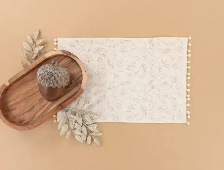 Wooden tray with acorn, patterned placemat and beige background decor.