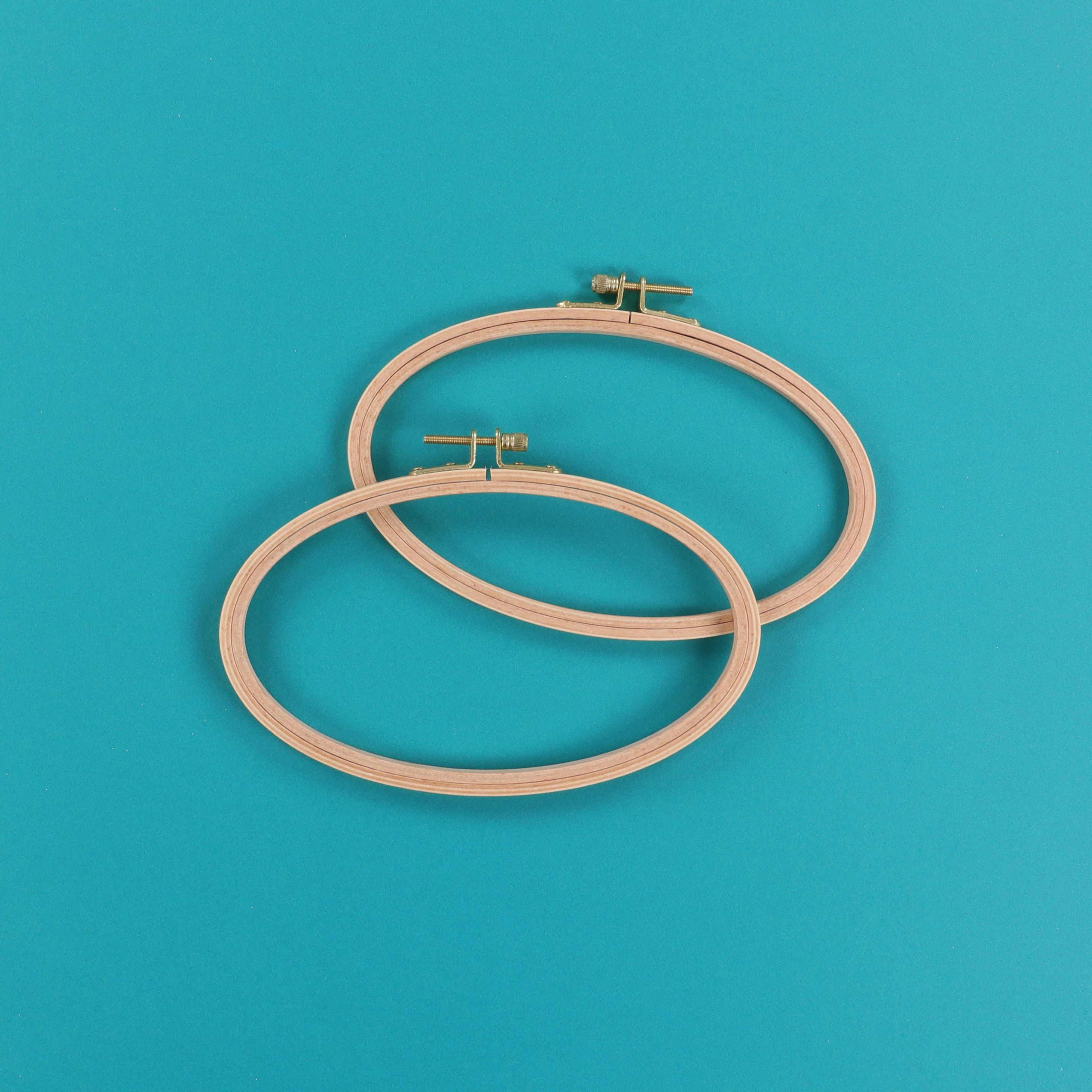 Two wooden embroidery hoops on a bright blue background