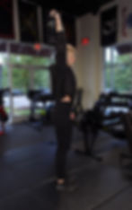 Image of a woman pressing a kettlebell into the air over her head.