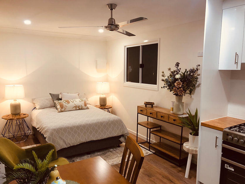 An open plan living area with dining and bed