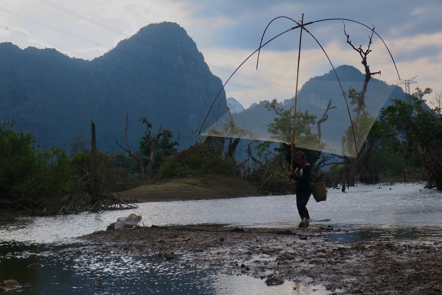 Fisherman casting net in Laos