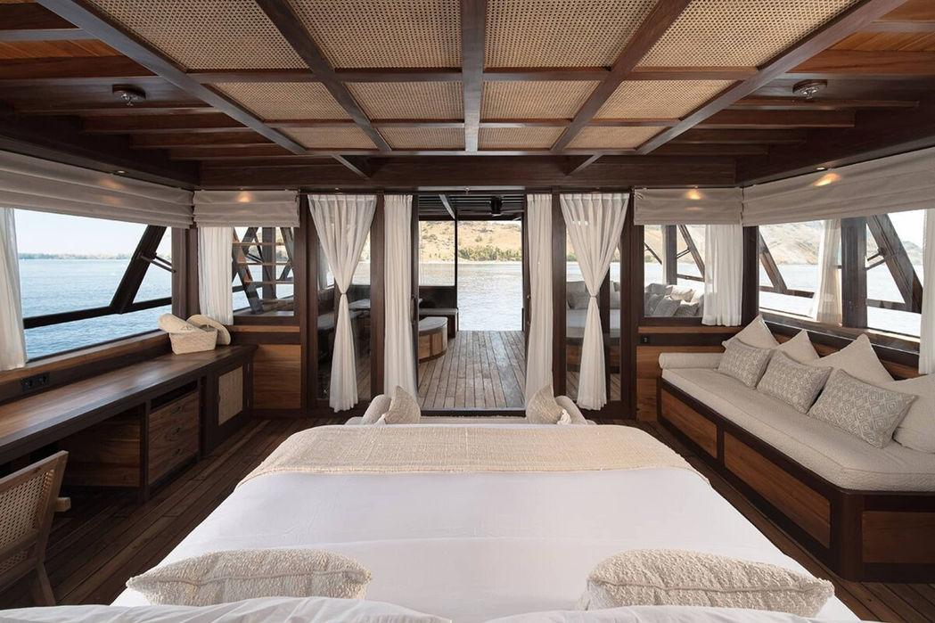 Master cabin with king bed and open window view aboard Sanya yacht