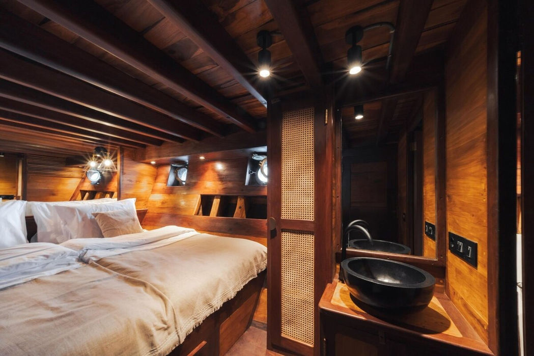 Guest cabin with twin beds and minimalist design aboard Nataraja yacht