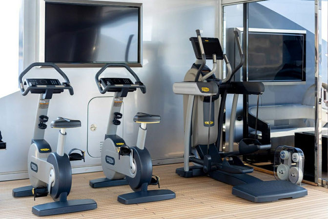 Indoor fitness area with treadmills and equipment onboard yacht
