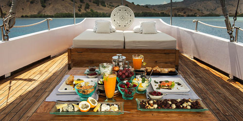 Gourmet breakfast served on deck of a luxury Phinisi yacht in Indonesia with ocean views