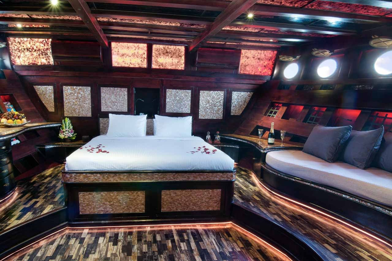 Cozy guest cabin with white sheets and carved wooden details aboard Mantamae yacht