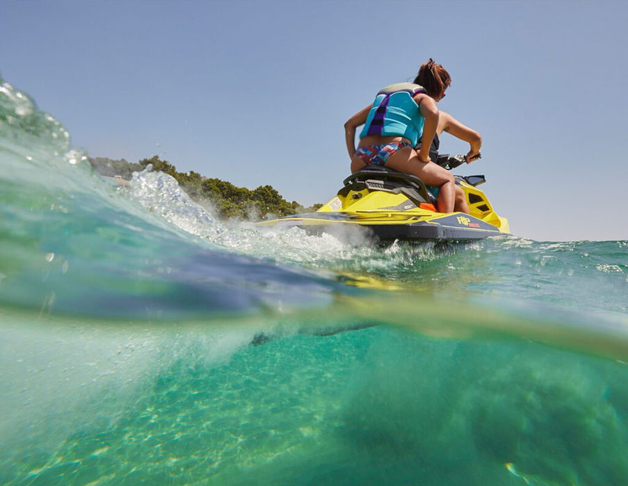 Man riding a jet ski on emerald waters in Sardinia’s Costa Smeralda.