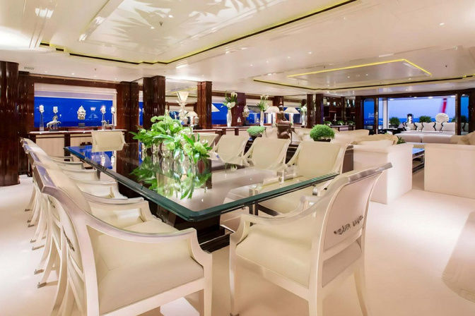 Spacious lounge with sofas and greenery on luxury yacht interior