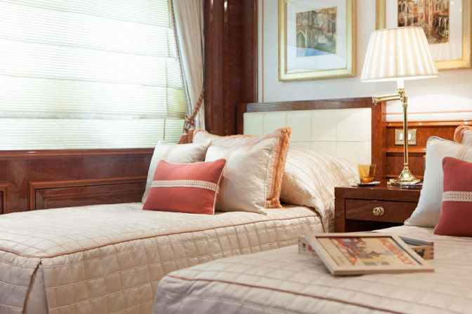 Cozy guest stateroom with twin beds and sofa