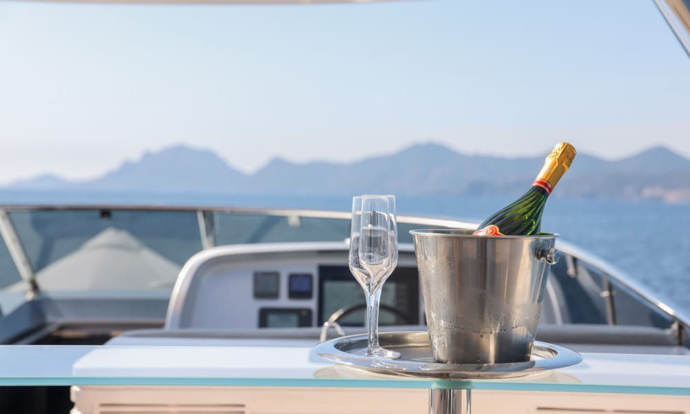 Champagne bucket and glasses set on yacht deck table