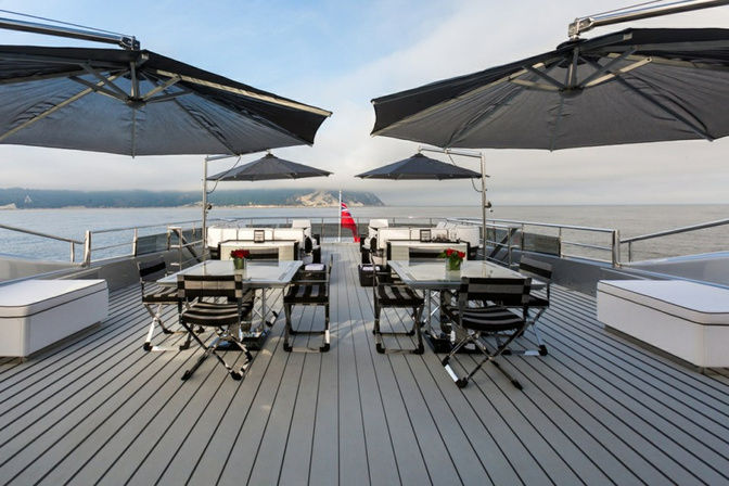 Open-air dining table setup on the deck of a luxury yacht